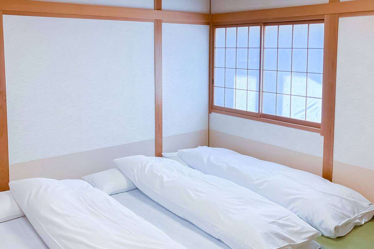 Una stanza con un letto, una finestra e un termosifone.