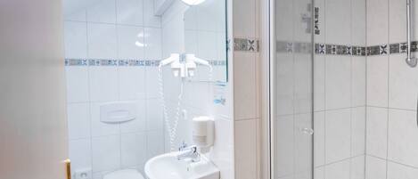 A bathroom with a toilet, sink, and shower.