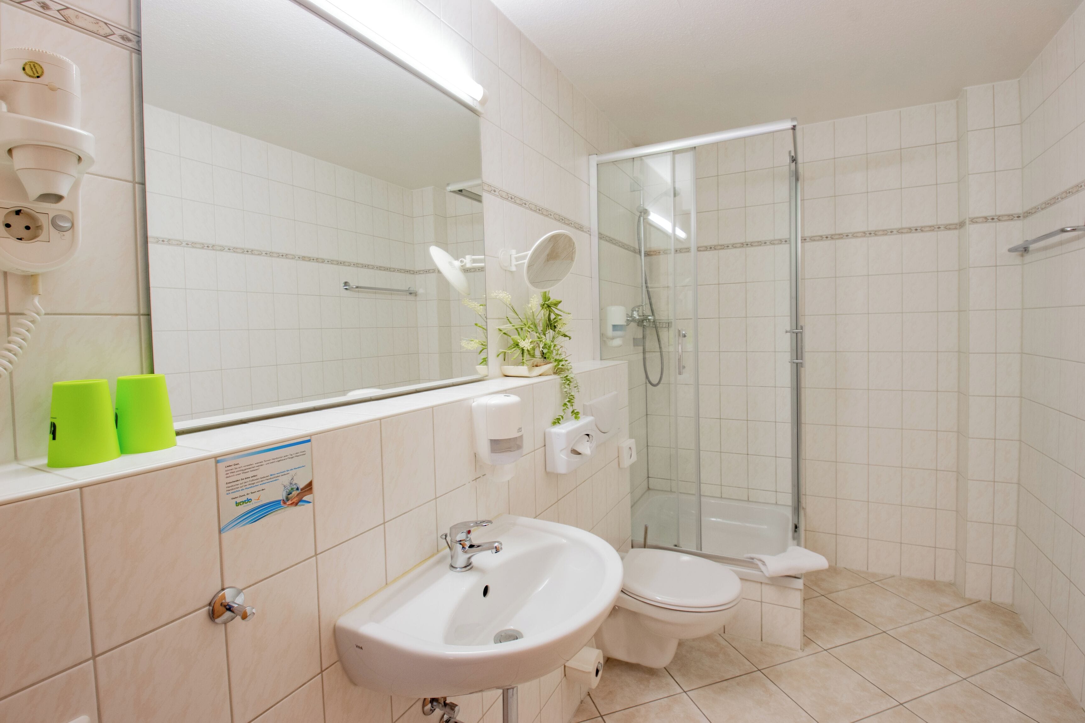 A modern bathroom with a sink, toilet, and glass-enclosed shower.