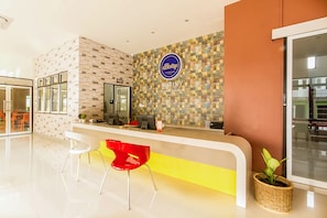 A hotel reception area with a modern design, featuring a reception desk, a digital screen, and a signboard. - Bestiny Hotel and Restaurant PHETCHABUN (Nong Phai)