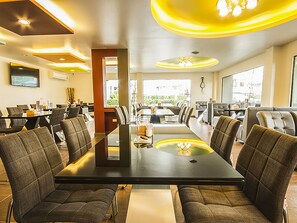 A modern conference room with a long table, comfortable chairs, and a large screen. - Bestiny Hotel and Restaurant PHETCHABUN (Nong Phai)