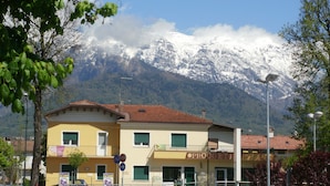 A two-story building with a yellow facade, a balcony, and a sign that reads "PROGETTI". - B&B Villa Norma (Feltre)