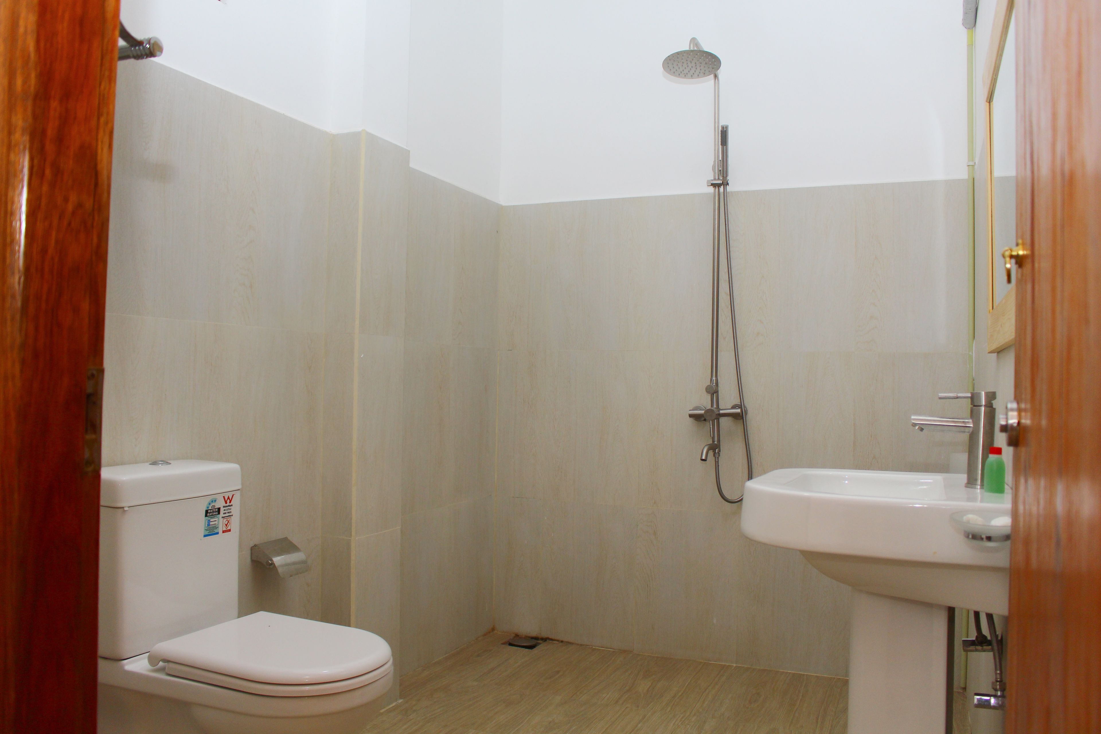 A small bathroom with a toilet, a shower, and a sink.