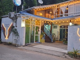 Un edificio con una escalera, un letrero que dice 'AARADHYA MIRISSA' y una estructura decorativa con forma de ala.