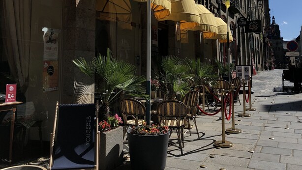 A row of outdoor seating with yellow umbrellas, a flag, and a sign for a hotel named "BALZA". - Balzac Hôtel (Fougeres)