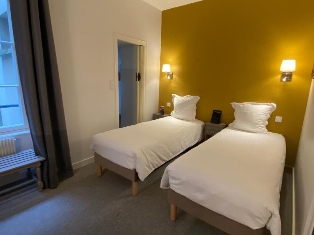 A hotel room with two single beds, a bench, and a door leading to a balcony.
