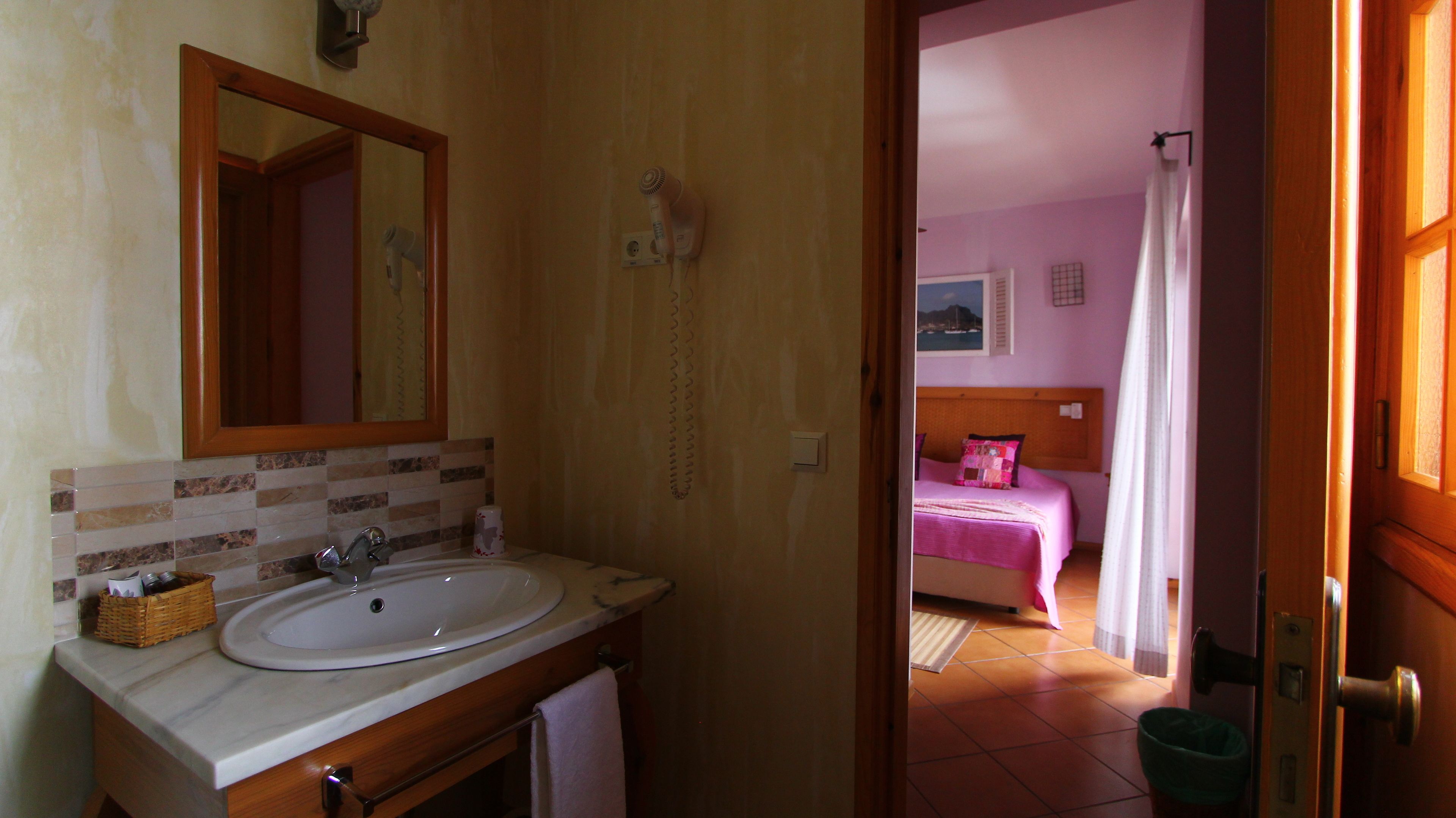A bathroom with a sink, mirror, and towel rack.