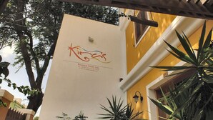 Señalización de 'Kiras Hotel' con datos de contacto y un logotipo.