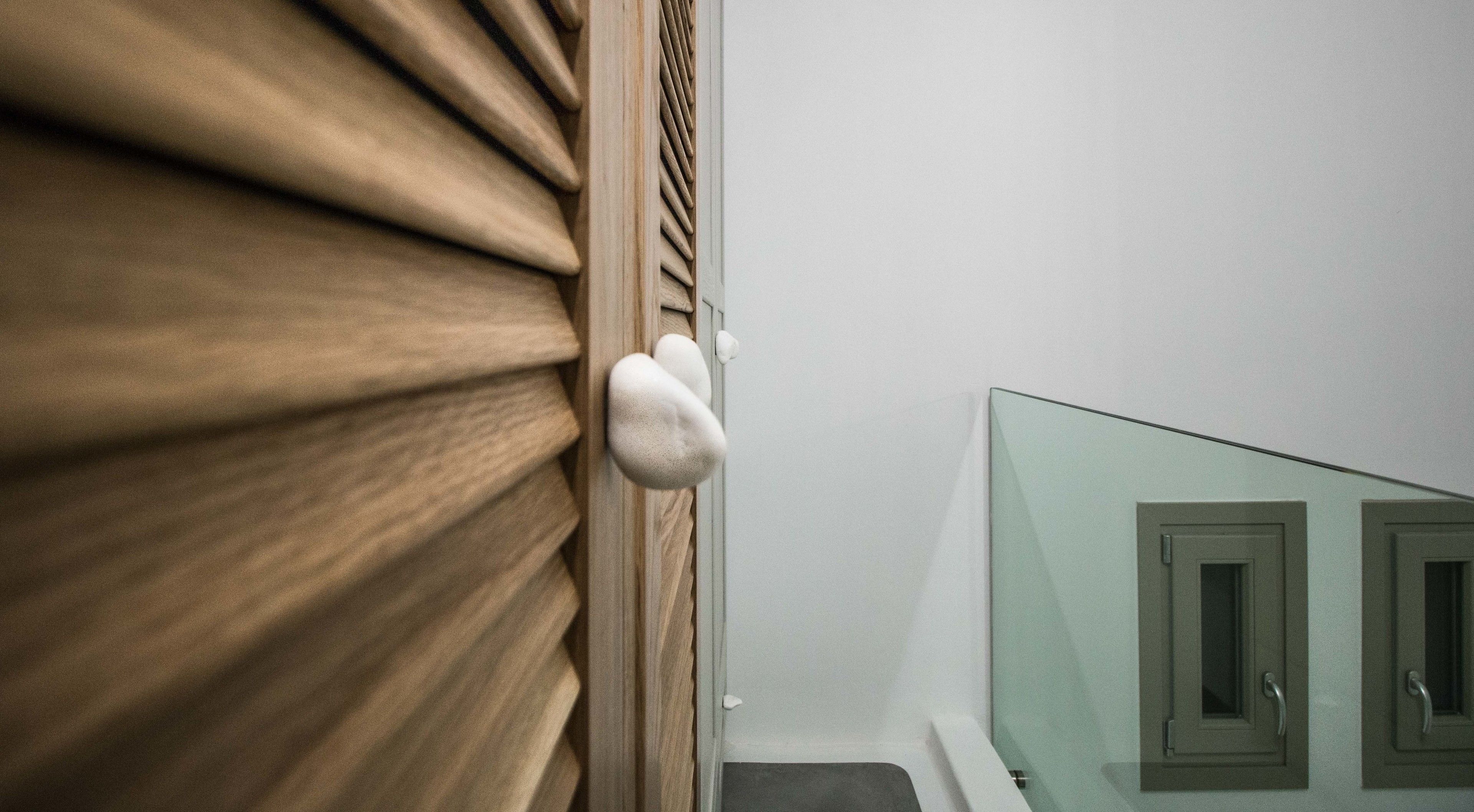 A wooden door with a textured surface and a glass panel with a handle.