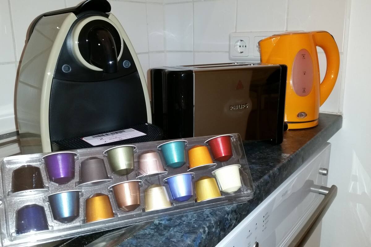 A kitchen with a coffee maker, a toaster, and a kettle on the counter.