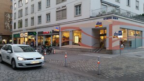 A building with a storefront labeled 'dm' and 'SPAR'. - Goldfisch Apartment Central Park (Vienna)