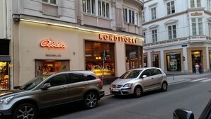 A street view with a building labeled 'Konditorei' and 'Aldia' on the facade. - Goldfisch Apartment Central Park (Vienna)