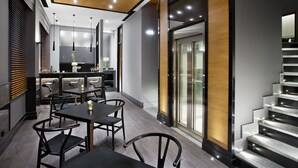Un interior moderno con comedor, cocina y escalera.