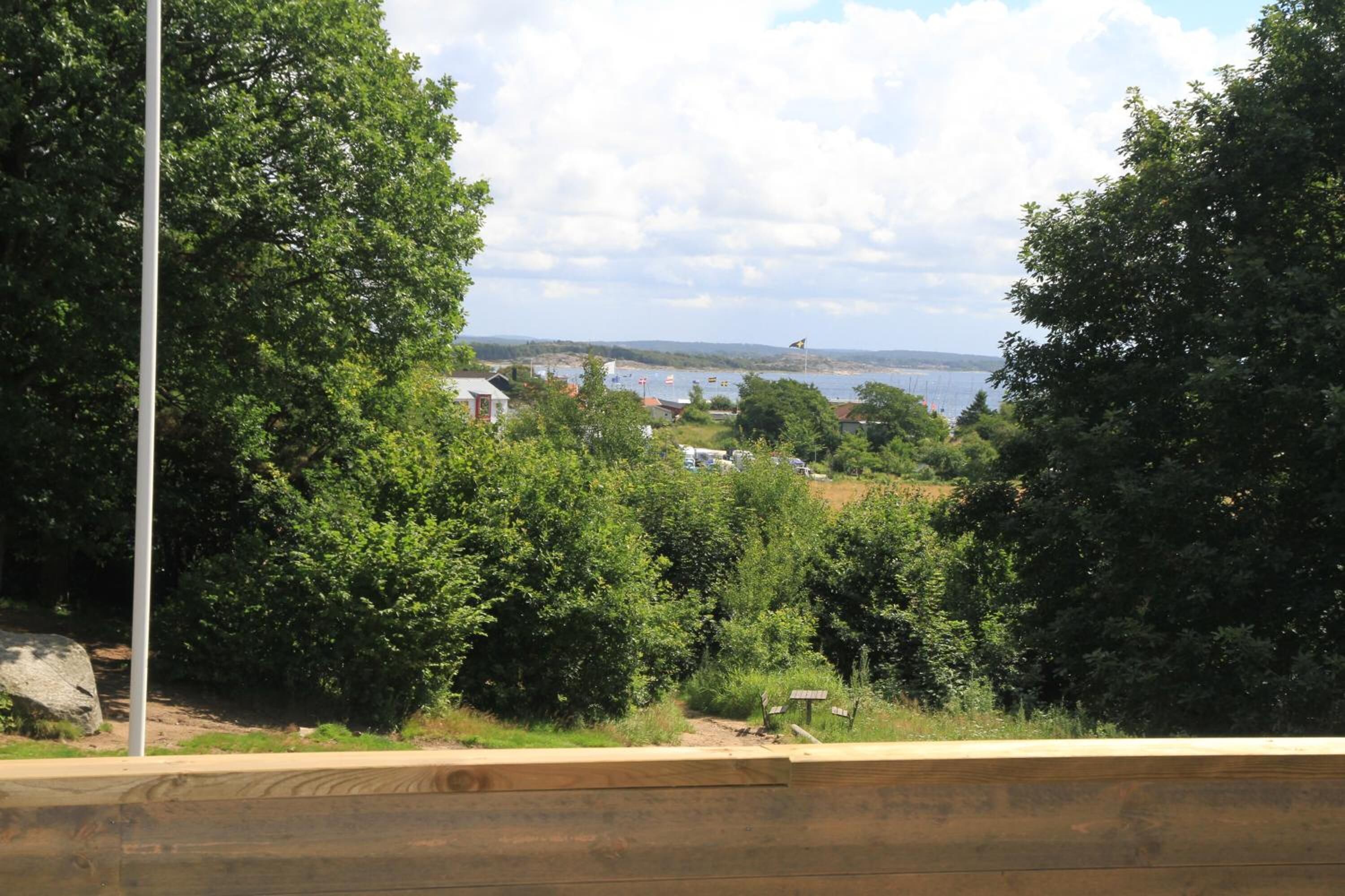 A view of a coastal town with dense greenery and a clear sky.