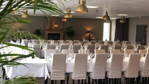 A banquet hall with multiple round tables set for dining, featuring white tablecloths and beige chairs. - Gottskär Hotell & Konferens  (Gottskar)
