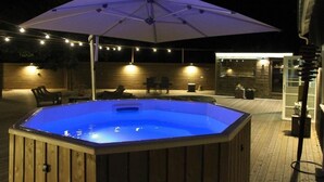 A hot tub with a wooden exterior and a white umbrella overhead. - Gottskär Hotell & Konferens  (Gottskar)