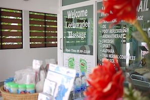 A massage parlor with a sign listing services like foot reflexology and aromatherapy. - Naithon Beach Mansion (Sa Khu)