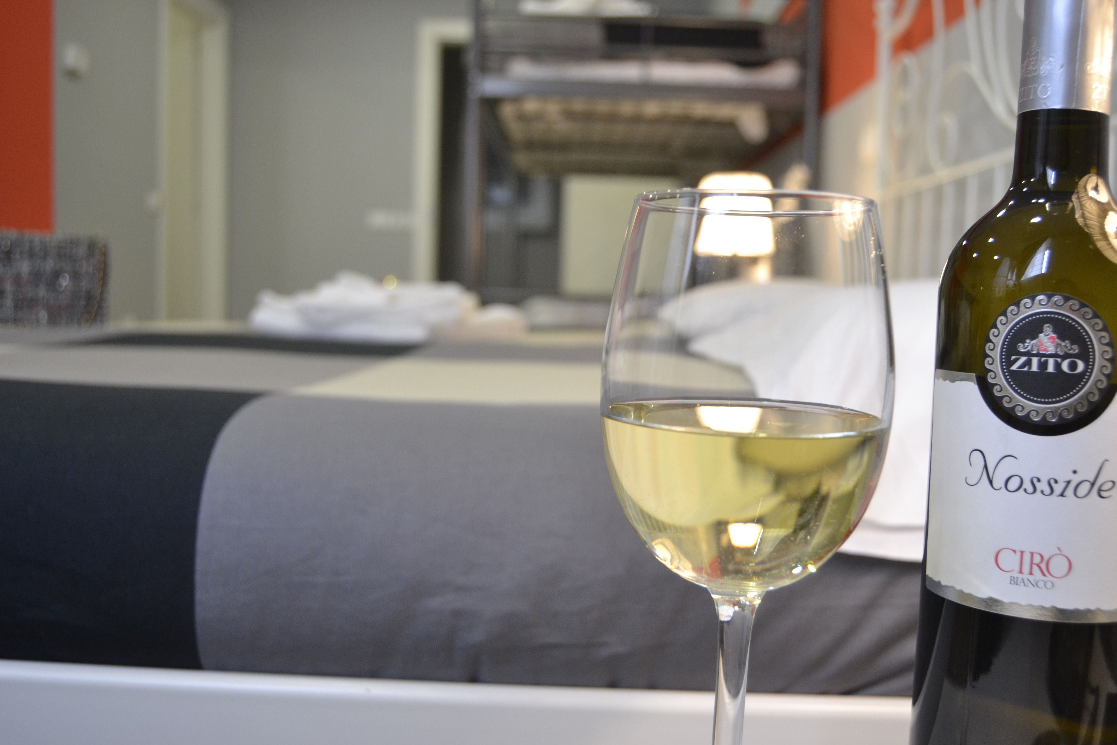 Eine Flasche Nosside-Wein und ein Glas Weißwein auf einem Tisch in einem Hotelzimmer.