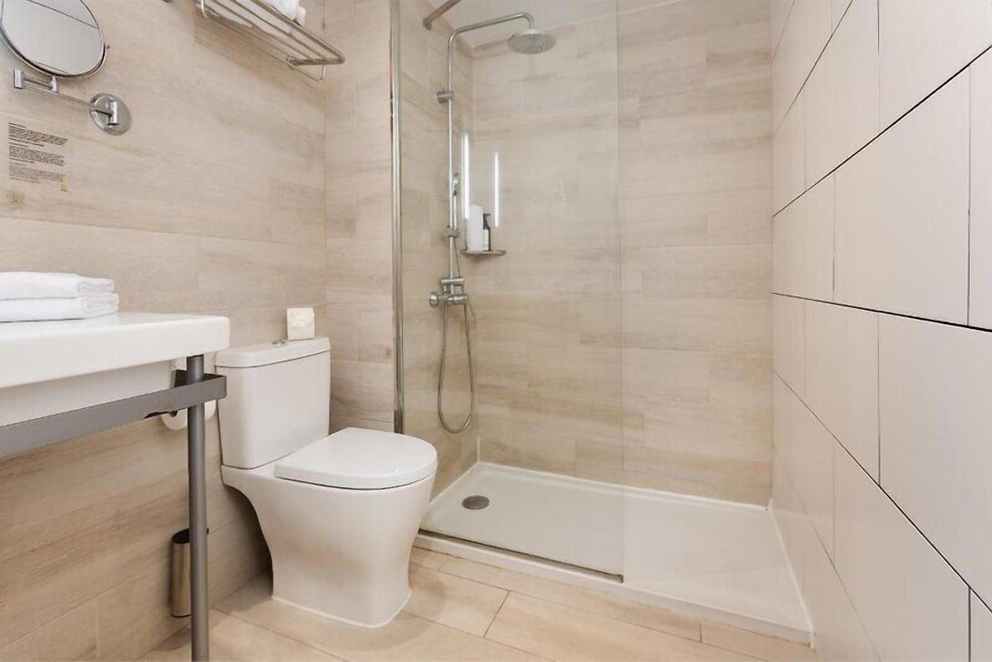 Une salle de bain moderne équipée de toilettes, d’un lavabo et d’une douche.
