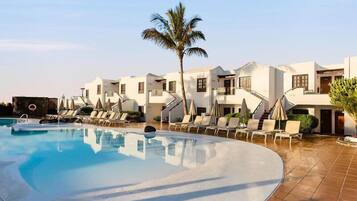 Een buitenzwembad, parasols voor strand/zwembad