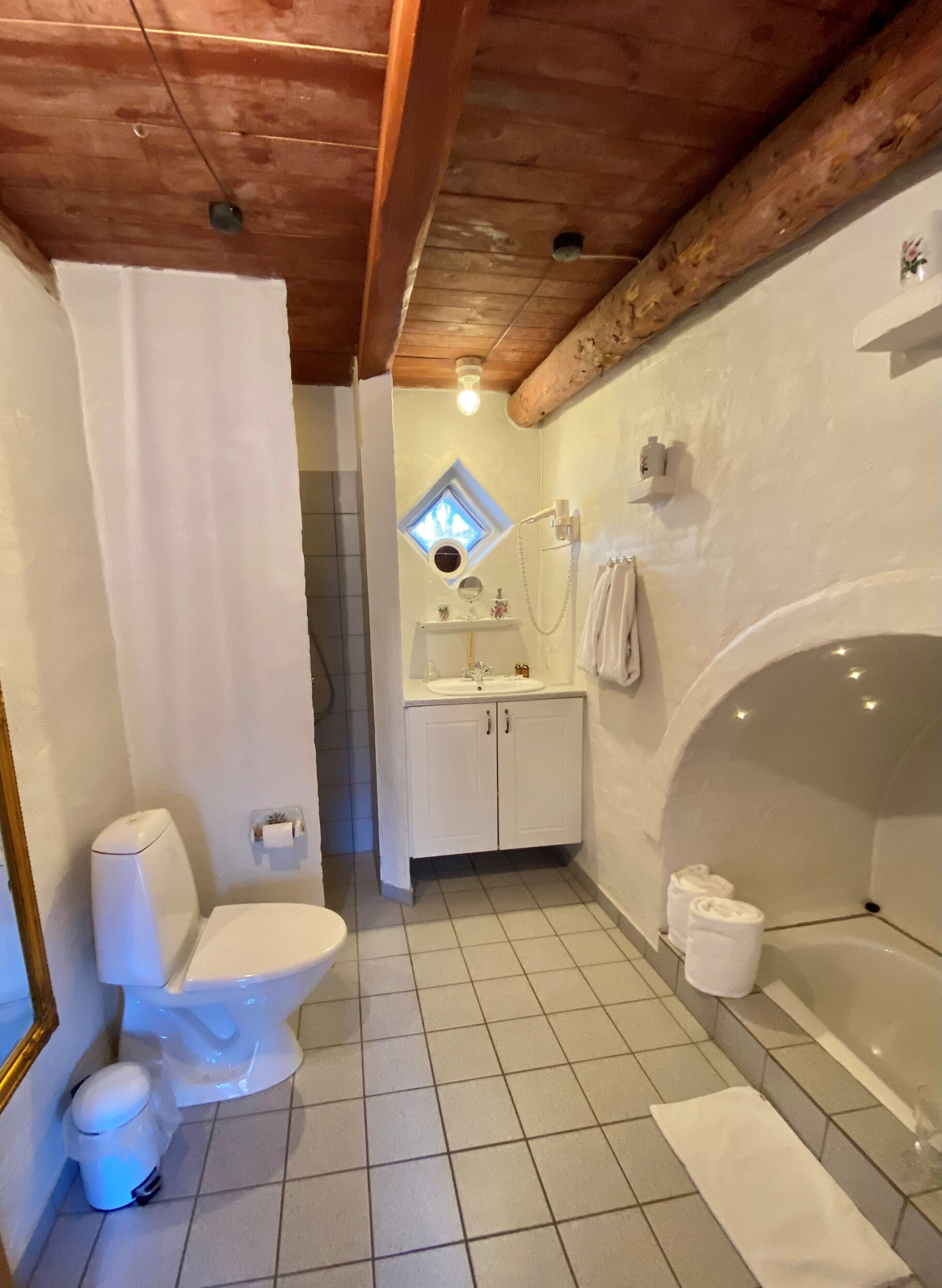 A bathroom with a toilet, sink, and bathtub.