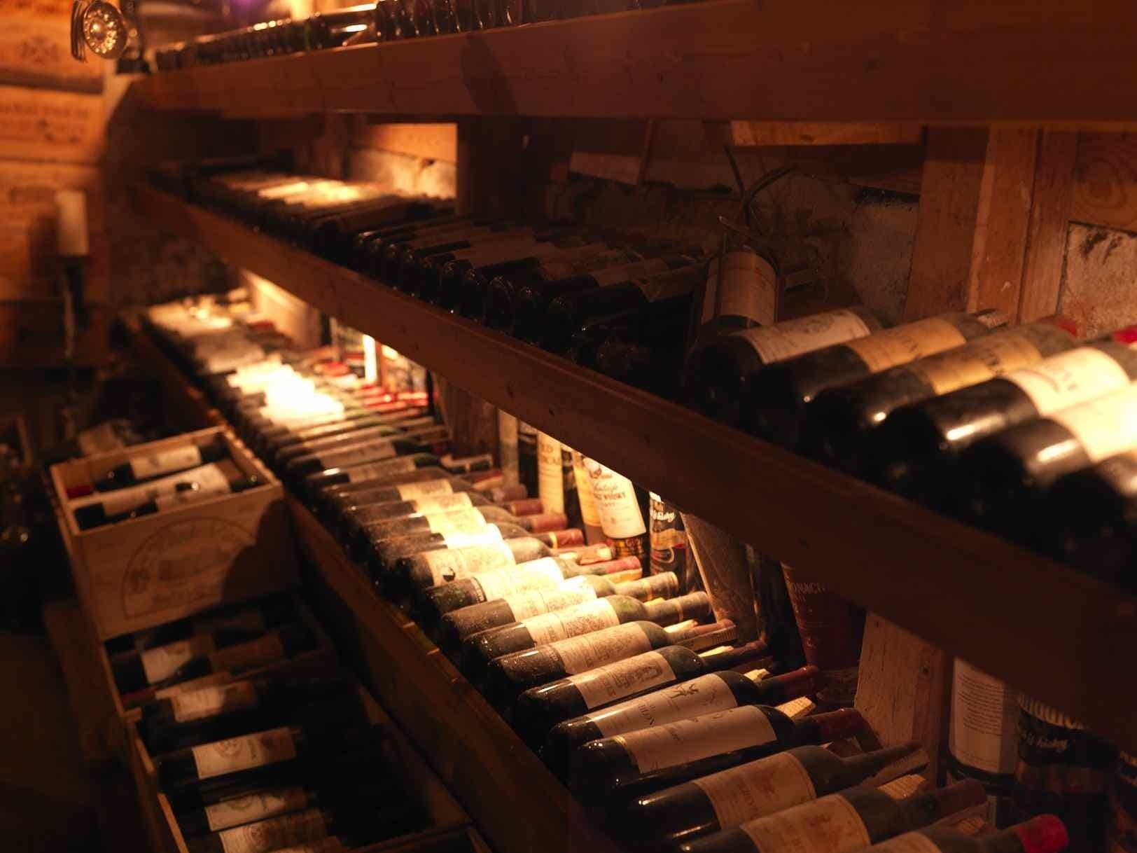 Una bodega con hileras de botellas de vino sobre estantes de madera.