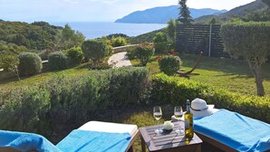 A terrace with a table set for two, overlooking a vineyard and the sea. - Villa Mirothea (Alonissos)