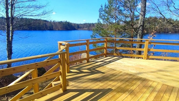 A wooden deck with a railing overlooking a lake. - Långasjönäs Camping & Stugby (Asarum)