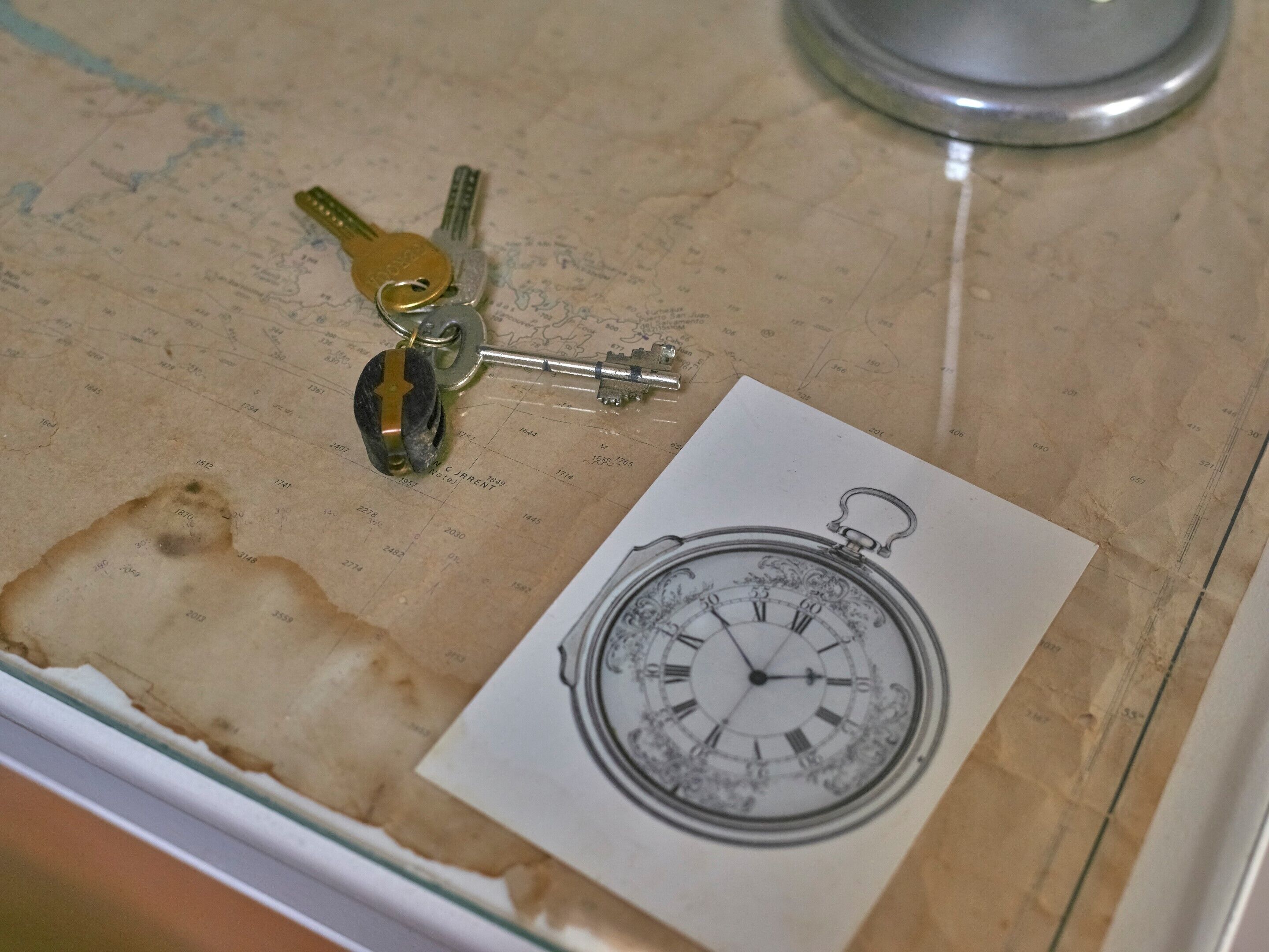 Eine Karte mit Illustrationen von Schlüsseln und einer Taschenuhr.