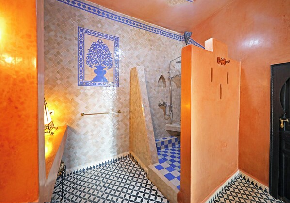 A bathroom with a tiled floor, a shower, and a sink. - Ryad Watier (Essaouira)