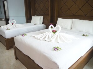 Two hotel beds with white linens and decorative swan-shaped towels.