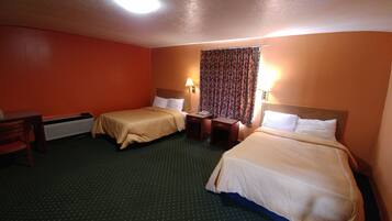 A hotel room with two beds, a desk, and a chair.