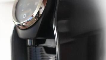 Una macchina da caffè con display digitale e portabicchieri.