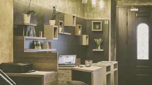 Eine moderne Küche mit Laptop, Kaffeemaschine und einem Blumentopf.