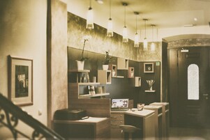 A modern interior with a desk, chair, shelves, and hanging lights.