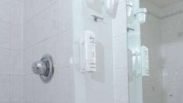 Un baño con un lavamanos blanco, espejo y barra para toallas.