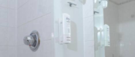 Un baño con un lavamanos blanco, espejo y barra para toallas.