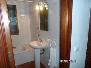 Une salle de bain avec un lavabo, un miroir et une baignoire.