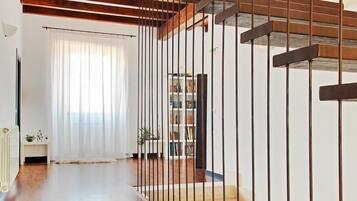Una escalera con detalles de madera y barandales de metal que desciende a un nivel inferior.