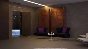 Un moderno cuarto de spa con dos sillones oscuros, una mesita con una tetera y un gran panel de pared de madera.