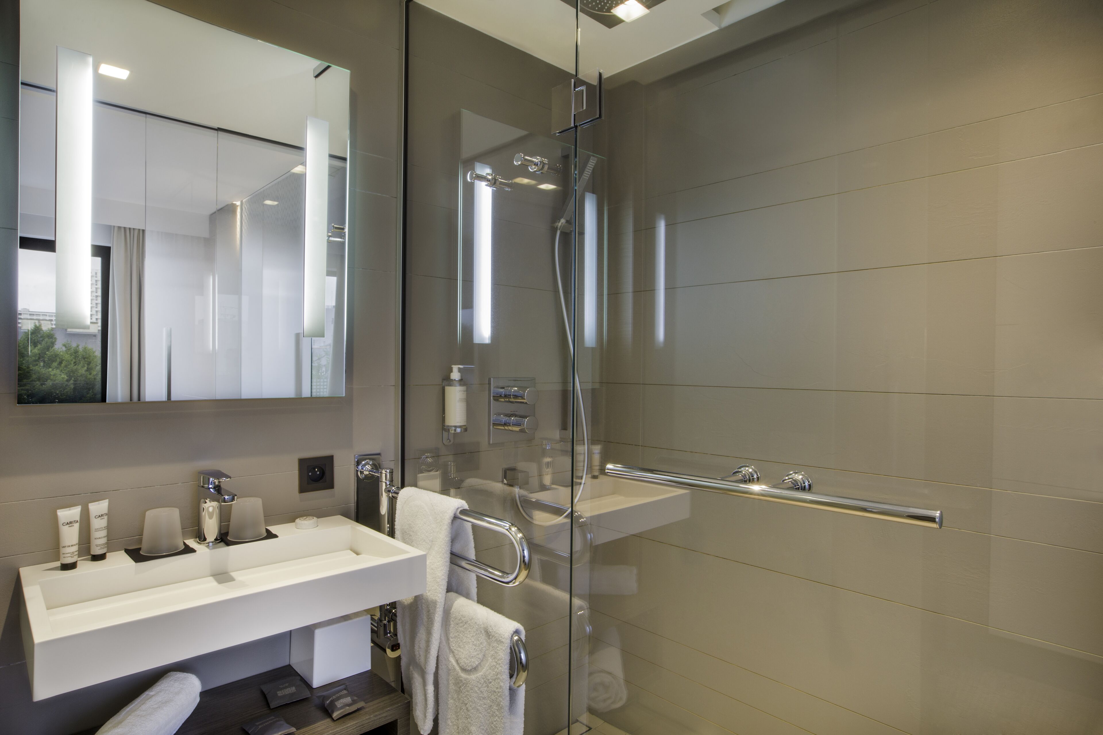 Une salle de bain moderne avec une douche à parois de verre, un meuble-lavabo et un grand miroir.