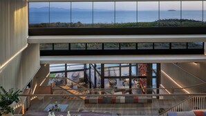 A modern interior with a view of the sea, a staircase, and a dining area. - Six Senses Kaplankaya (Milas)