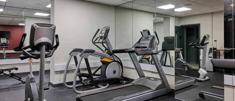 A gym with treadmills, elliptical machines, and stationary bikes.