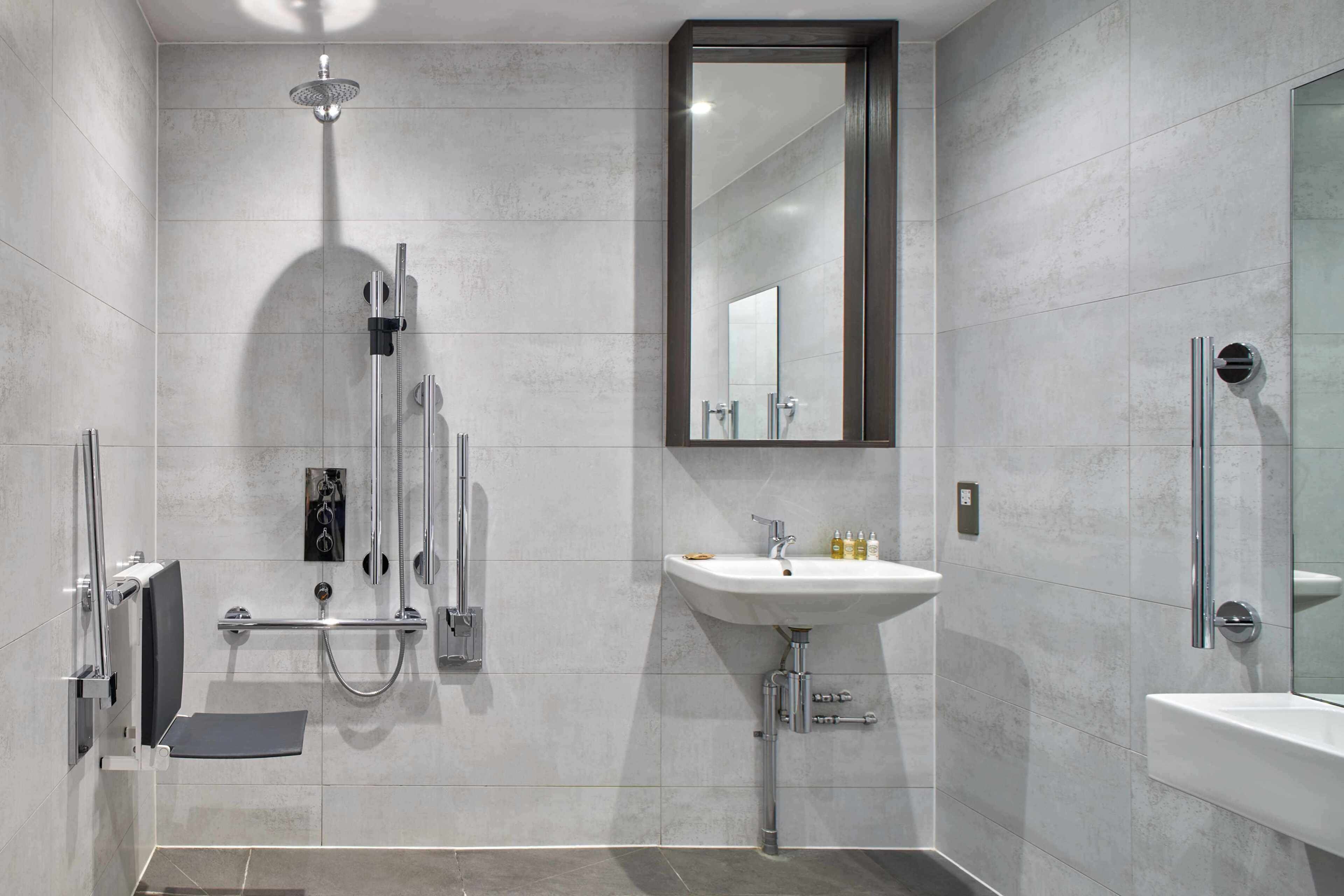 Ein modernes Badezimmer mit Dusche, Waschbecken und Spiegel.