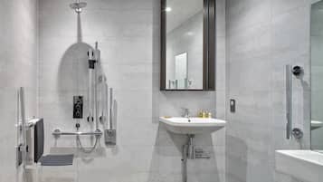 Ein modernes Badezimmer mit Dusche, Waschbecken und Spiegel.