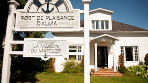 A white building with a sign reading "Port de Plaisance D'Alma" and "Hébergement La Maison du Matelot". - La Maison du matelot (Alma)