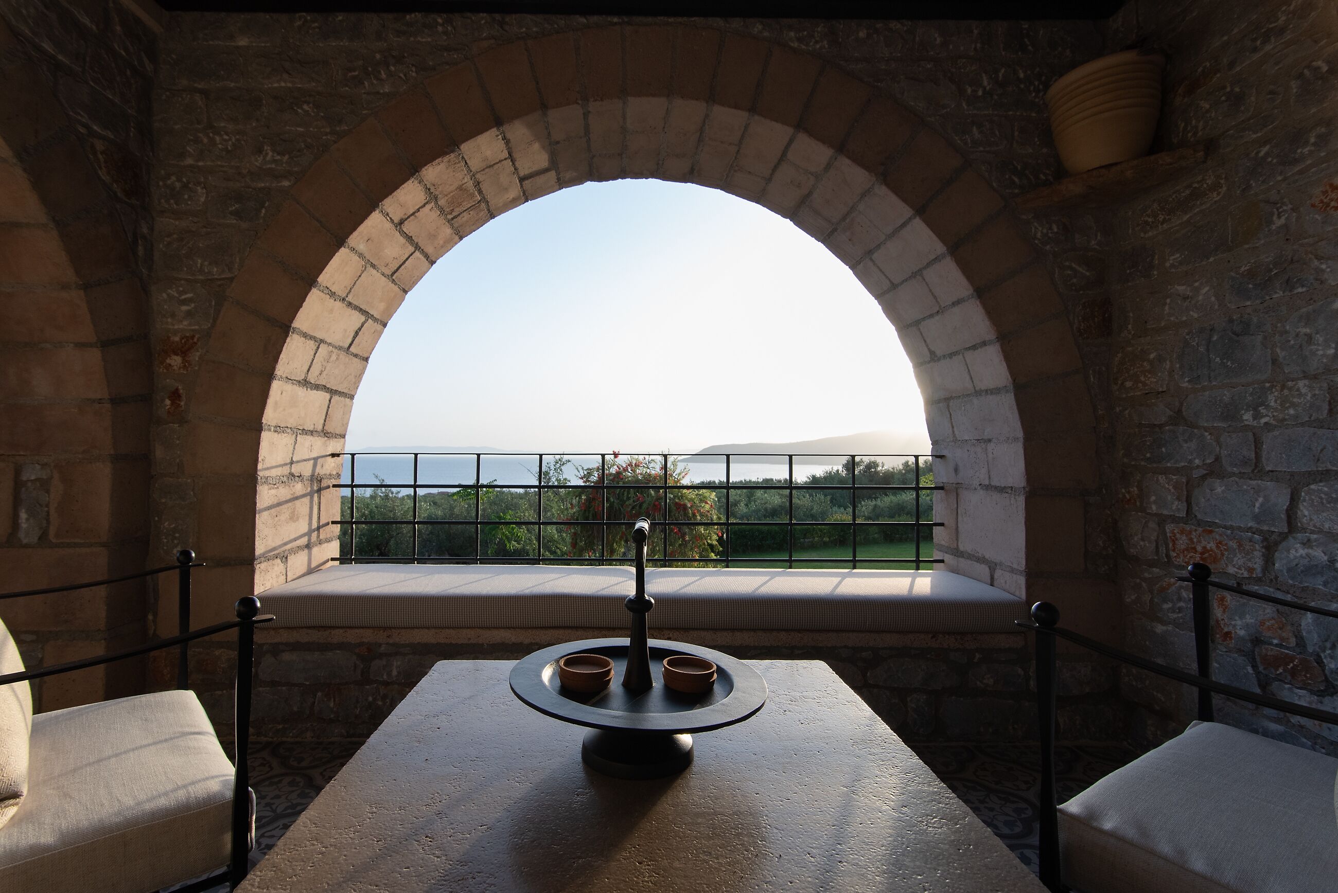 Una habitación con paredes de piedra y un amplio ventanal con vistas al paisaje.