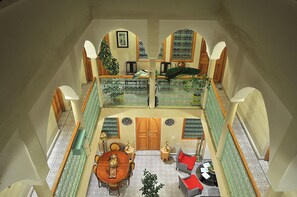 A spacious interior with a high ceiling, a central dining area, and seating arrangements.