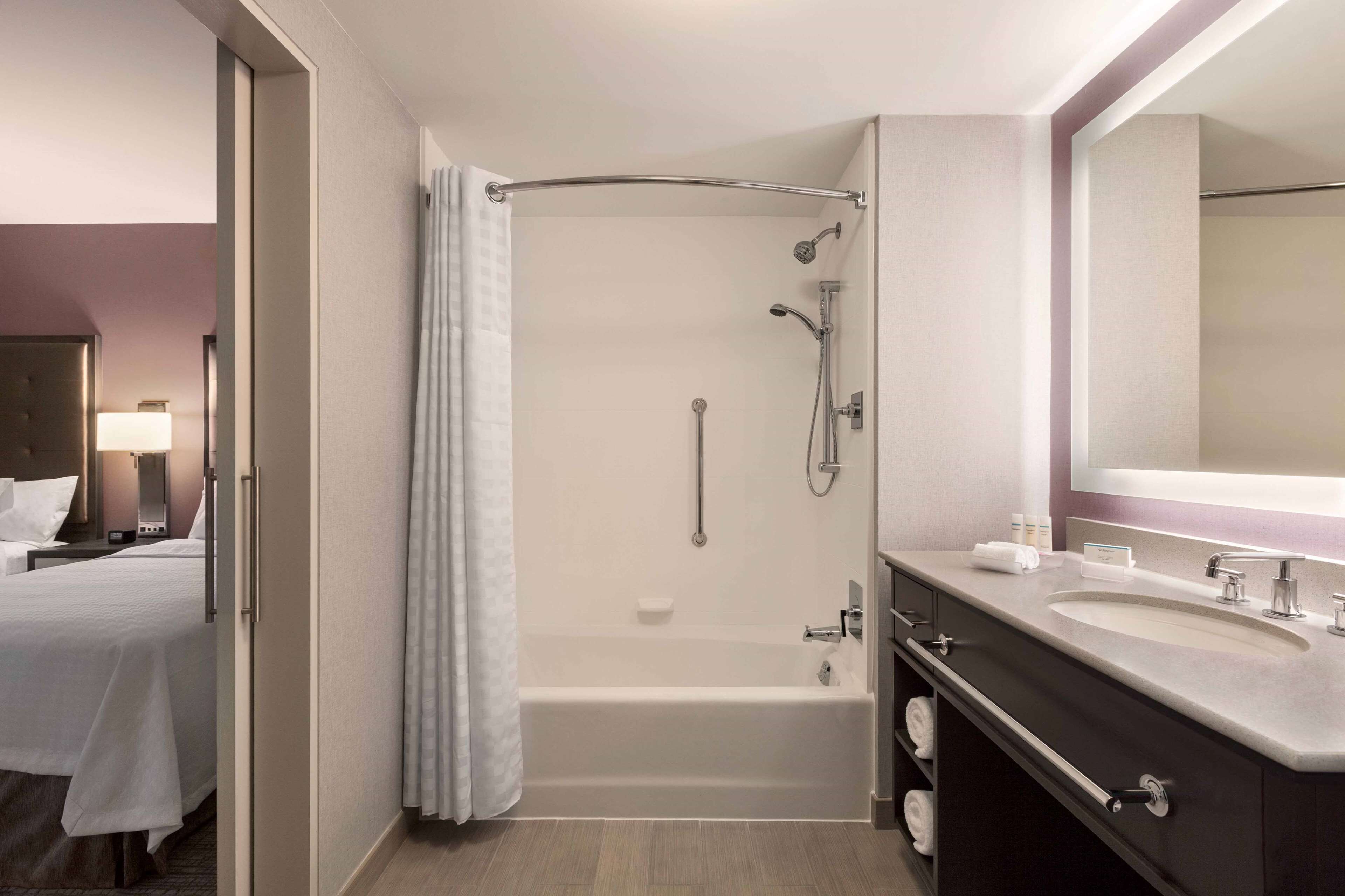 Une salle de bain moderne avec une baignoire, deux lavabos et un grand miroir.