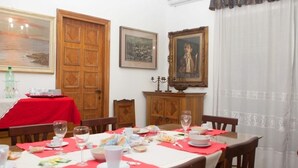Un comedor con una mesa dispuesta para una comida, rodeado de armarios de madera y cuadros en las paredes.